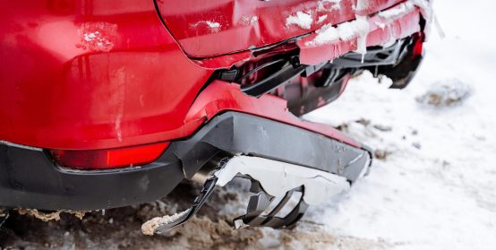 Broken car bumper. Accident on the road. The red car has a broken rear trunk. The plastic in the car cracked.